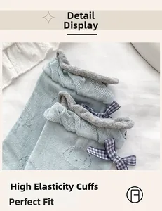 Detail of light blue cotton socks featuring cute puppy embroidery and grey ribbed cuffs