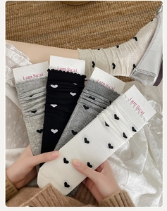 Détail de chaussettes en coton quatre couleurs avec motif jacquard cœur et côtes