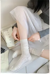 Detail of white mesh crew socks with hollow cherry and heart patterns for women