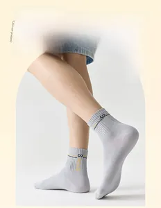 Dettaglio calzino a costine grigio chiaro con strisce sportive e scritta SOCKS