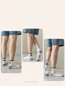 Detail of cotton crew socks with smiley face pattern and blue rib cuff on male model