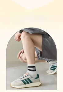 Close-up of lightweight cotton striped crew socks worn with retro green sports sneakers