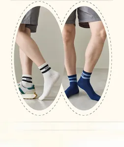Detail of white and navy men's cotton socks with striped cuffs and FAST lettering