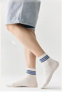 Detailed view of white athletic crew socks featuring classic blue and black striped cuffs