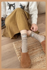 Detailed texture of thick wool socks with egg letter patch and warm ribbed knit pattern