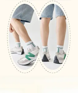 Dettaglio macro di calze traspiranti con strisce verdi e sneaker dallo stile retrò