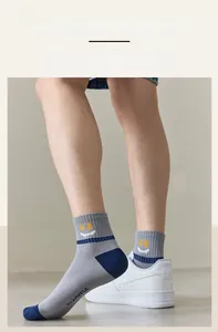 Close-up of grey cotton socks with blue contrast and yellow smiley face pattern