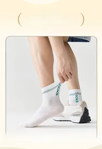 Dettaglio del polsino elastico largo su calze sportive bianche con strisce verdi