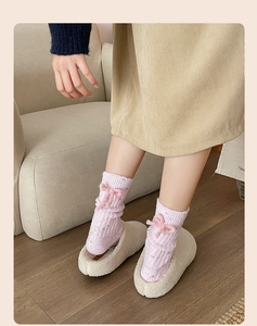 Pink cashmere wool socks with side bow detail and warm chunky knit texture on model
