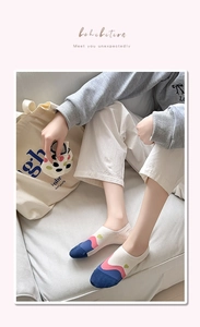 Detail of breathable cotton boat socks featuring navy toe and green heart pattern