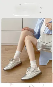 Calze bianche con bordo a volant in maglia traspirante e scarpe da ginnastica argento