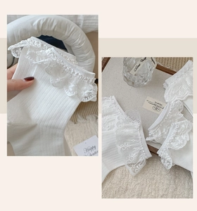 Detailed close-up of white cotton socks featuring delicate lace embroidery and ribbed texture