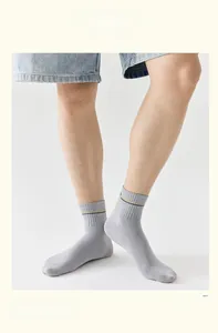 Dettaglio calzini da uomo in cotone grigio chiaro con strisce gialle e blu navy sui polsini