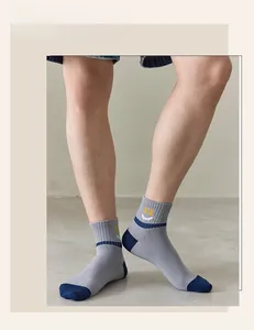 Detail of grey crew socks for men with blue heel and yellow smiley face pattern