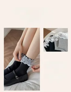 Macro shot of gray ribbed knit socks with elegant white polka dot lace ruffled cuffs