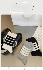 Detail of ribbed knit stripe socks in black, white and grey with classic four-bar design