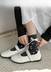 Détail de chaussettes gris foncé avec jacquard cœur blanc et nœud en soie décoratif