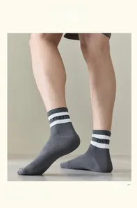 Close-up of dark grey cotton sports socks featuring white stripes and FAST lettering