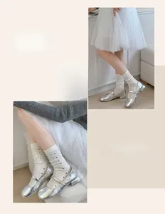 Detail of silver Mary Jane shoes with white mesh hollow dot socks and elegant buckles