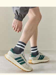 Detail of striped cotton socks with FAST text paired with retro leather sneakers