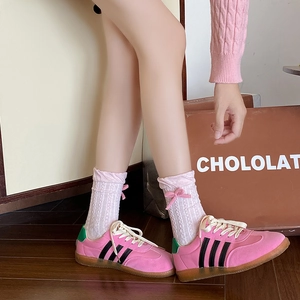 Pink bow tie ribbon crew socks with cable knit pattern paired with classic fashion sneakers