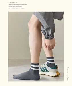 Detail of dark grey crew socks featuring white stripes and FAST lettering in cotton rib