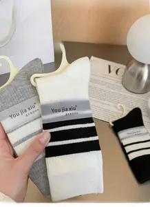 Detail of striped crew socks with high elasticity and rib-knit texture in packaging