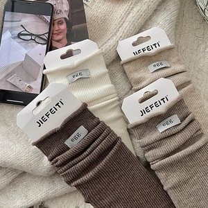Cozy rib-knit crew socks with egg. letter label in cream, brown, and khaki colors