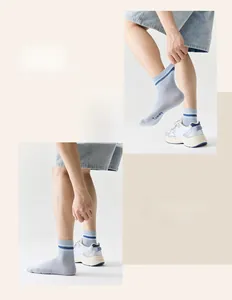 Detail of light blue striped athletic cotton socks worn with white sneakers
