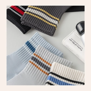 Macro detail of ribbed athletic socks in five colors with striped cuffs and soft texture