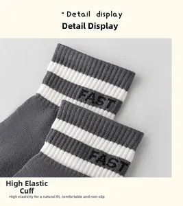 Close-up of the high-elasticity ribbed cuff and FAST lettering on gray striped socks