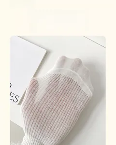 Detail showing the thin breathable cotton fabric and lace trim of the white socks