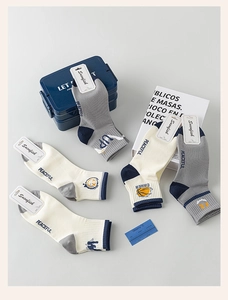 Close-up of five pairs of cotton socks with peaceful text and basketball embroidery