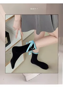 Detail of black Lolita socks featuring high elasticity and light blue ribbon bows