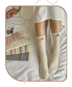 Detail of cream lace socks with pink bows and floral patterns in five pair set