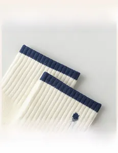Detail of high-elastic ribbed cuffs on white cotton socks with blue trim finish