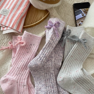 Three pairs of knit cashmere socks with cute bows in pink, lavender, and grey colors