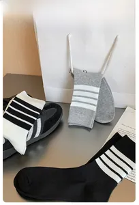 Detailed knit texture of mid-calf socks with classic four-stripe sporty design