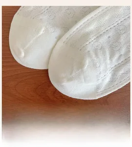Detail of white mesh baby socks featuring breathable holes and seamless toe design