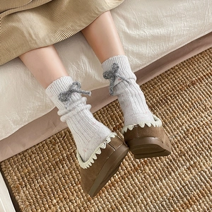 Beige cashmere blend thermal socks with grey plush bow detail and vertical knit texture