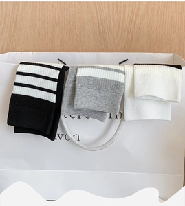Close-up of three striped crew socks with ribbed texture hanging on a shopping bag