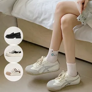 Baskets beiges pour femmes et chaussettes en coton blanc avec motif chat mignon chez soi