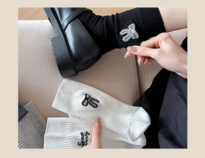 Detailed embroidery of sweet candy lettering and bow on ribbed cotton crew socks