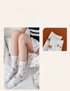 Detail view of white crew socks featuring cute cartoon cat and rabbit knit patterns