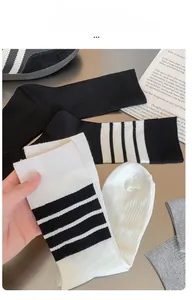 Detail of high-elasticity striped mid-calf socks in black, white, and grey colors