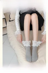 Detail of grey ribbed cotton socks with white heart pattern lace trim shown on model