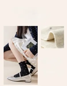 Detail of black polka dot crew socks with frill cuffs and cotton fabric texture