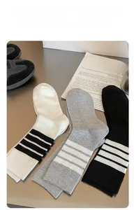 Close-up of ribbed cotton crew socks in white, grey and black with stripe details