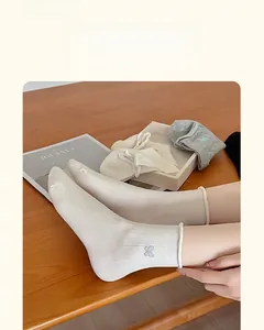 Detail of embroidered butterfly cotton socks featuring breathable thin fabric texture