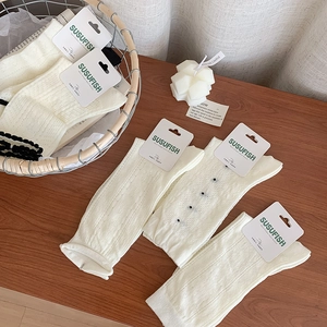 White breathable mesh cotton socks for women displayed on a natural wood surface